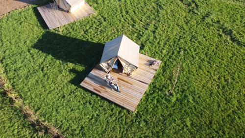 an overhead view of a wooden house in a field at Camping à la ferme - Hébergements insolites in Cerisy-la-Forêt