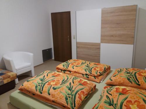 FischbachにあるFerienwohnungen "Johannesberg"のベッド3台と白い椅子が備わる客室です。