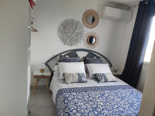 a bedroom with a blue and white bed with pillows at Shoumy in Les Trois-Îlets