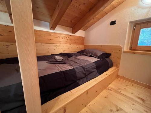 uma cama num chalé de madeira com uma janela em m&m cabins em Gordona