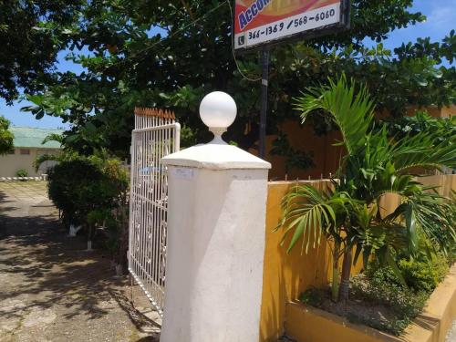 a white gate with a street sign next to a fence at Entire 6-Bedroom Villa Free parking with Fast Wifi in Discovery Bay