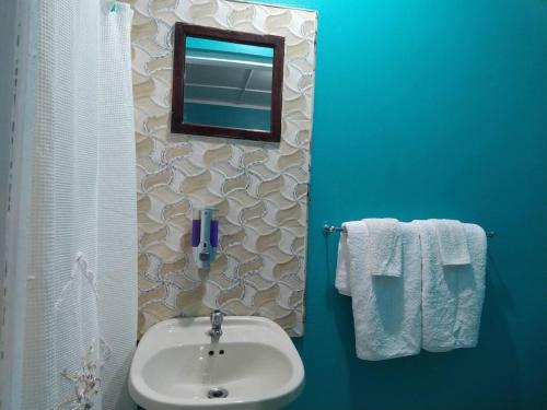 a bathroom with a sink and a mirror and towels at Entire 6-Bedroom Villa Free parking with Fast Wifi in Discovery Bay
