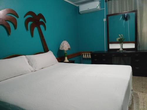 Schlafzimmer mit einem weißen Bett und einem Spiegel in der Unterkunft Entire 6-Bedroom Villa Free parking with Fast Wifi in Discovery Bay