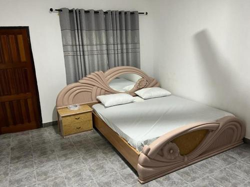 - une chambre avec un lit et une tête de lit en bois dans l'établissement Inviting 3-Bed House in Accra, à Accra