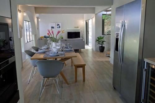 a kitchen and dining room with a table and refrigerator at Villa Adina - A luxury villa with pool, perfect for a quiet hideaway or an exotic escape in Westerhall Land Settlement