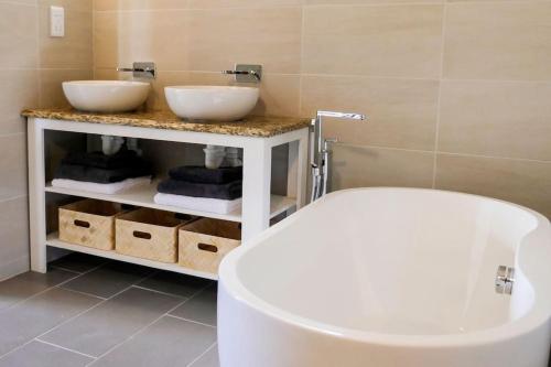 a bathroom with two sinks and a bath tub at Villa Adina - A luxury villa with pool, perfect for a quiet hideaway or an exotic escape in Westerhall Land Settlement