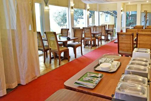 a dining room with a table and chairs and a table and chairsktop at Hotel Villa Des Gouverneurs in Puducherry