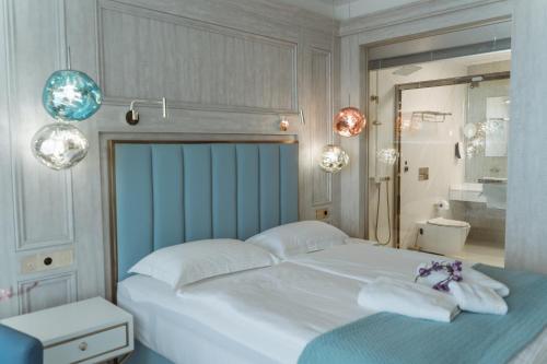 una camera da letto con un grande letto bianco con asciugamani di Hotel Maris a Ulcinj