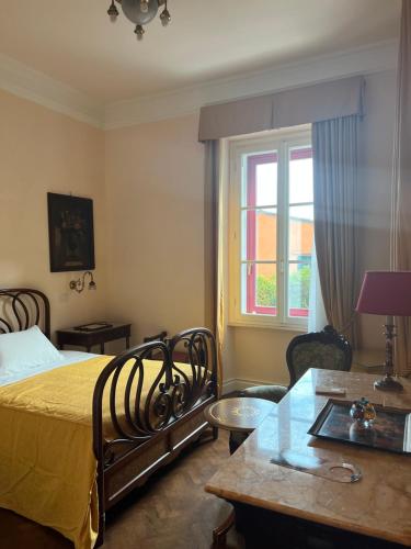 a bedroom with a bed and a table and a window at Dimora Villa Ricci in Pedaso