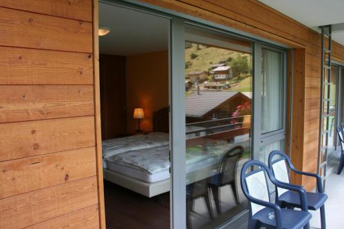 Zimmer mit einem Balkon mit einem Bett und Stühlen in der Unterkunft Welcome Hotel Täsch by Täscherhof in Täsch