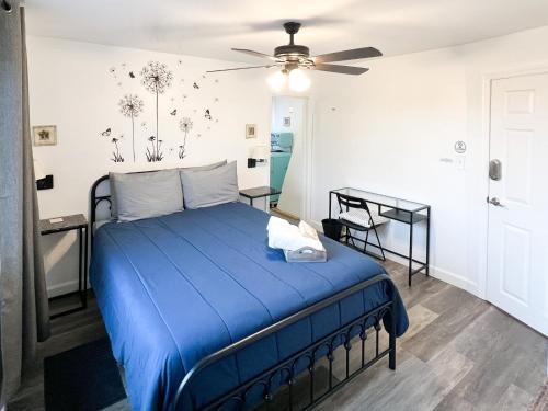 a bedroom with a blue bed with a ceiling fan at Sunny Queen bedroom feel like home!! in Englewood