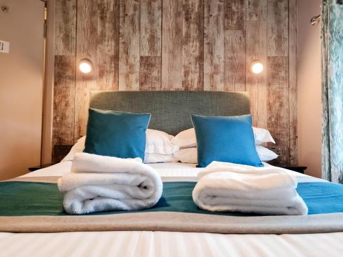 a bedroom with blue and white towels on a bed at Furzeleigh Mill Inn in Buckfastleigh