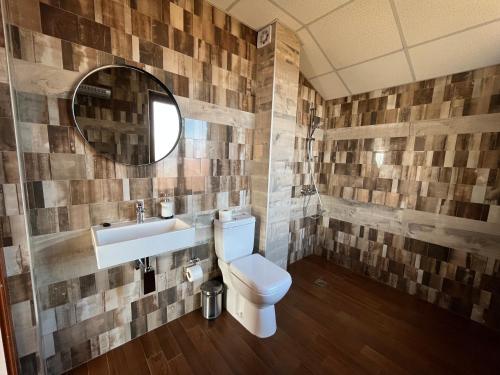 een badkamer met een toilet, een wastafel en een spiegel bij Farmhopping Village in Dobărsko