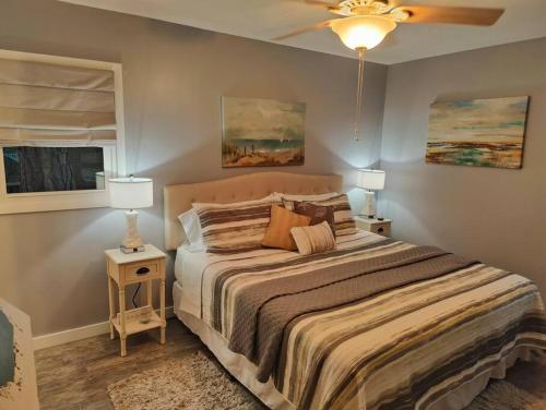 um quarto com uma cama com duas mesas de cabeceira e dois candeeiros em Jekyll Island House/ Kellys On The Coast /King bed em Jekyll Island