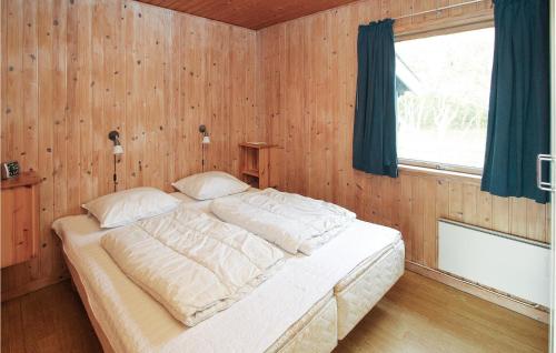 a bedroom with a large bed in a wooden wall at Beautiful Home In Samsø With Kitchen in Kolby Kås