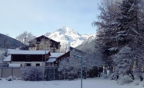 a house covered in snow with a mountain in the background at CIS-Ethic Etapes de Val Cenis in Lanslebourg-Mont-Cenis