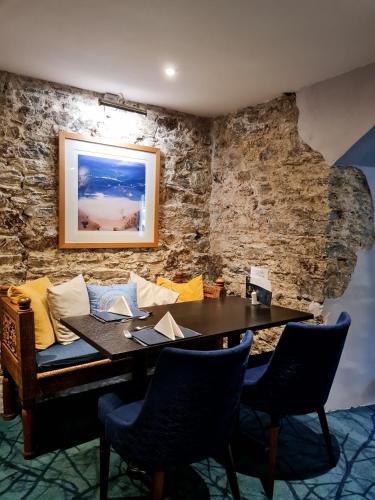 a dining room with a wooden table and chairs at Furzeleigh Mill Inn in Buckfastleigh