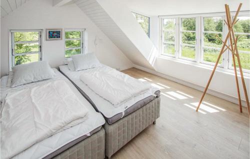 2 camas individuales en una habitación con ventanas en Cozy Apartment In Sams With Kitchen, en Ballen