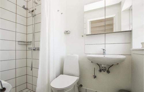 Baño blanco con aseo y lavamanos en Cozy Apartment In Sams With Kitchen, en Ballen