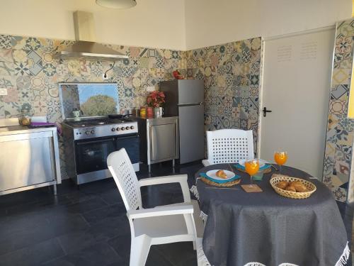 a kitchen with a table and chairs and a refrigerator at Habitaciones en Finca Olivo y Almendro in Ucenda