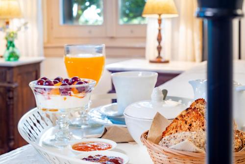 un tavolo con un cesto di pane e un bicchiere di succo d'arancia di Archontiko Angelou ad Alinda