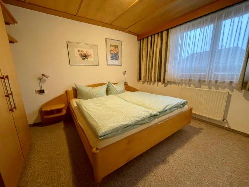 Schlafzimmer mit einem Bett und einem Fenster in der Unterkunft Ferienwohnung Martha in Obsteig
