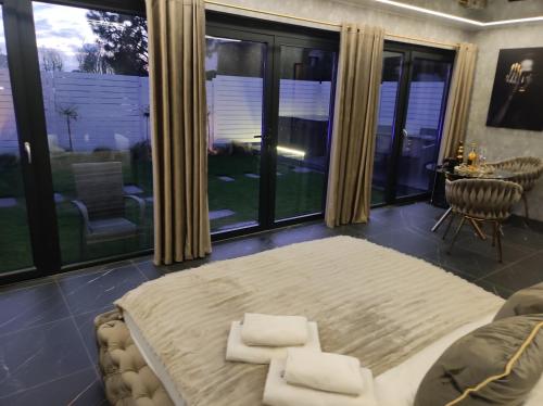 Pensjonat Wrzos في بوزنان: غرفة نوم كبيرة مع سرير كبير ونوافذ كبيرة
