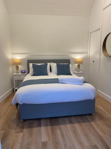 a bedroom with a large bed with blue pillows at Rural Retreat in Devon in Plymouth