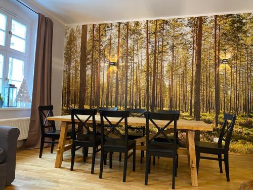 Leśniczówka Szeroki Bór في Szeroki Bór: غرفة طعام مع طاولة جدارية وأشجار