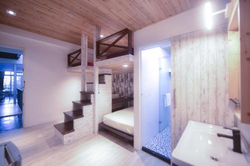a bathroom with a bunk bed and a sink and a staircase at CASA CoMoDo 自在家 in Tainan