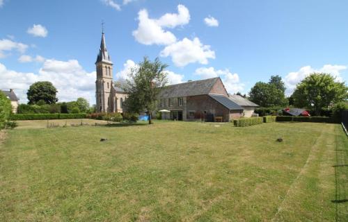 une église avec une cour herbeuse devant un bâtiment dans l'établissement La Meunière 2, à Montmerrei