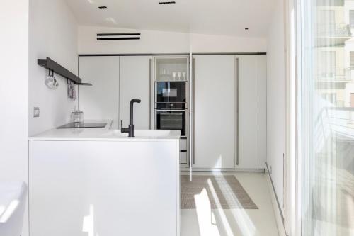 a white kitchen with a sink and a window at WeLive Trapani - luxury apartments in Trapani