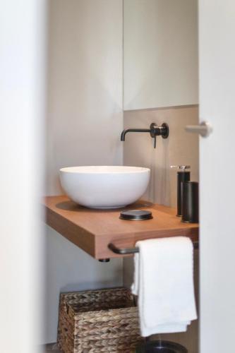 a bathroom with a bowl sink on a wooden counter at WeLive Trapani - luxury apartments in Trapani