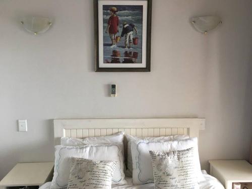 a bed with white pillows and a picture on the wall at Granada 105 in Margate