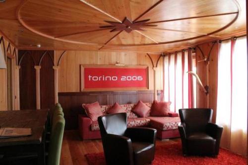 a living room with a couch and a table and chairs at Grand Hotel Sestriere in Sestriere