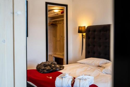a cat laying on a bed in front of a mirror at Grand Hotel Sestriere in Sestriere