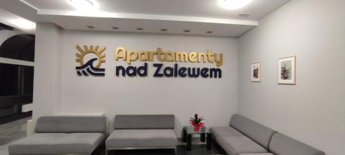 una sala d'attesa con divani e un cartello sul muro di Apartament Nad Zalewem Zegrzyńskim a Serock