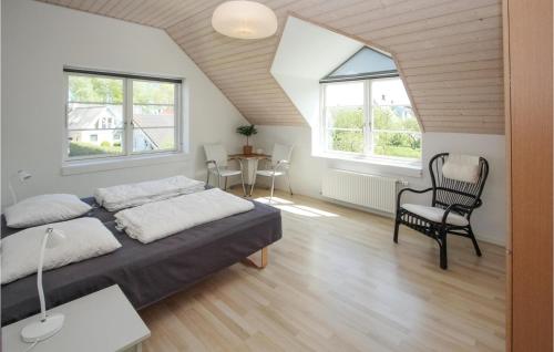 um quarto com uma cama, uma cadeira e 2 janelas em Amazing Apartment In Sams With Wifi em Ballen