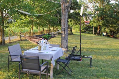 uma mesa com cadeiras e uma rede de descanso num quintal em Verde e tranquillità a Fucicchie em Cagli