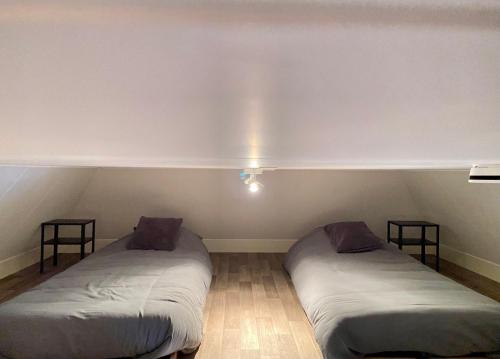 two beds in a room with a rainbow in the wall at De Parel B&B in Breezand