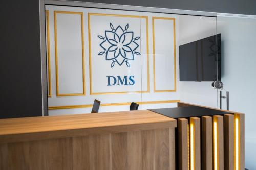 a room with a desk with chairs and a sign on the wall at DMS Apartments & Suites Sarajevo in Vogošća