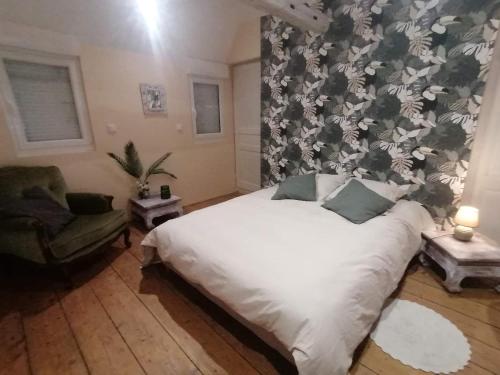 a bedroom with a white bed with a floral wallpaper at Château de bonneville Picardie in Bonneville