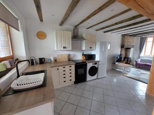 une cuisine avec un lave-linge et un sèche-linge sur un comptoir dans l'établissement Gite du Grand Chene, à Saint-Léger-Magnazeix