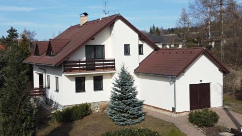 a white house with a brown roof at Chalupa u golfu Kořenec in Kořenec