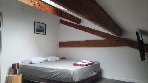 - une chambre avec un lit dans une pièce dotée de plafonds en bois dans l'établissement Beau T3 au cœur du centre ville, à Narbonne