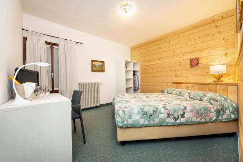 1 dormitorio con 1 cama y escritorio con TV en Hotel Ristorante Miramonti, en Santa Maria Maggiore