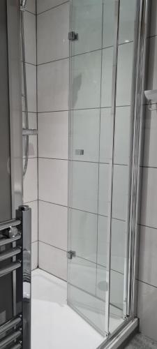 a shower with a glass door in a bathroom at Furzeleigh Mill Inn in Buckfastleigh