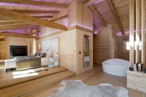 a bedroom with a large bed and a bath tub at Grand Chalet de Rougemont in Rougemont