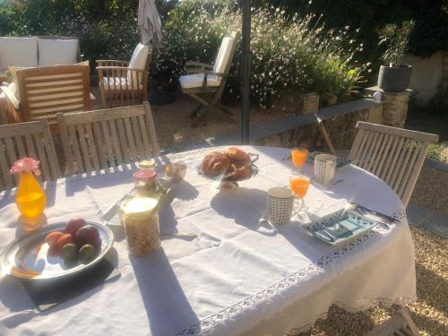 - une table blanche avec de la nourriture et des boissons dans l'établissement Le Clos Marie, à Fontaine-Milon