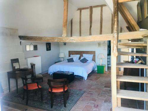 Un dormitorio con una cama y un piano en una habitación en Le Clos Marie, en Fontaine-Milon